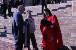 Rebecca Meiving (Phd) dons her red gown while making head or tails of the rest of her esteemed attire. Photo: Tendai Dube